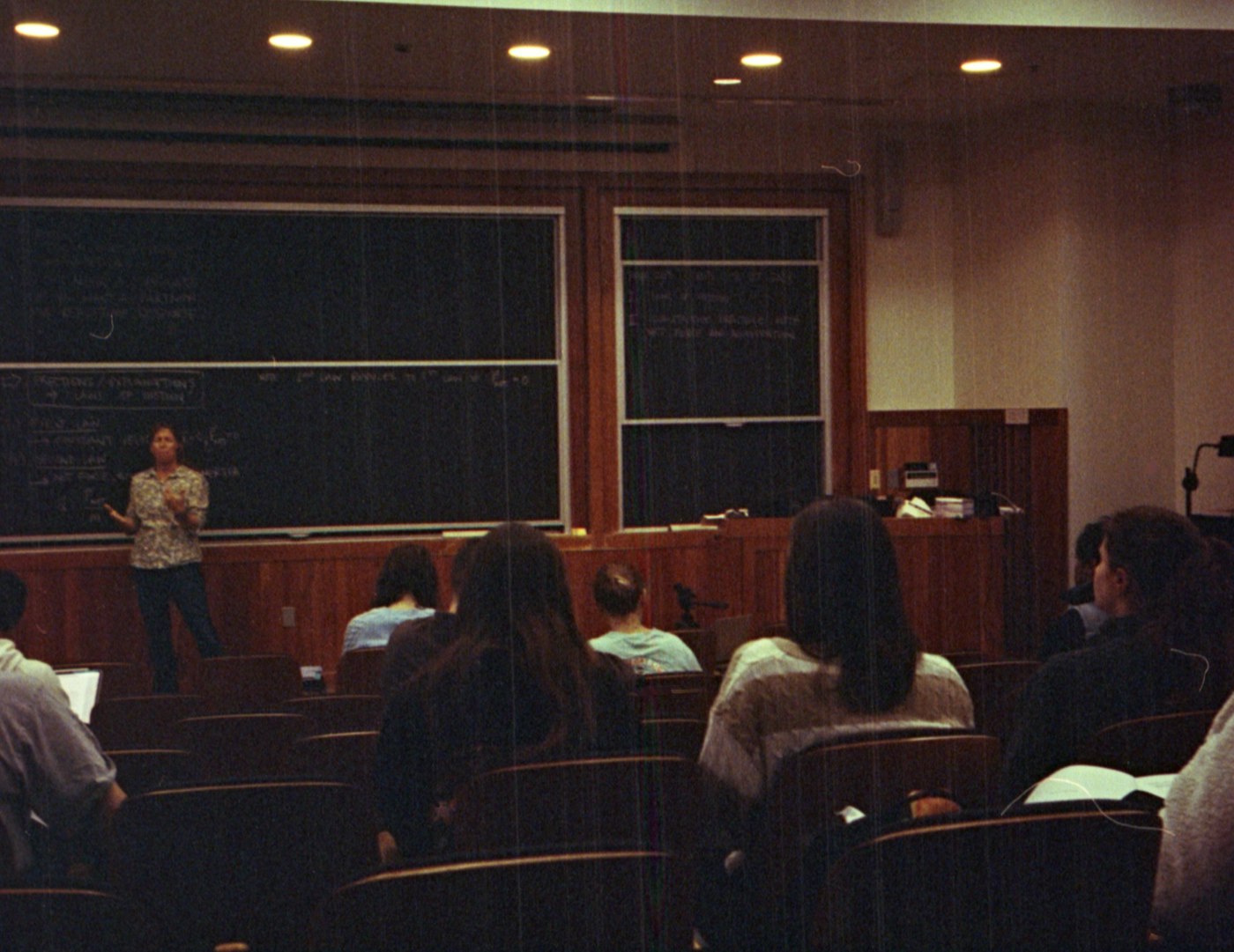 A faculty member leading a seminar at a lecture-hall blackboard